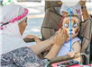 Child Getting Face Painted as a Tiger
