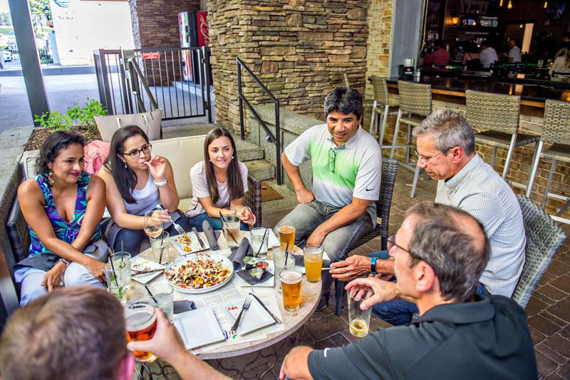 A group of people having dinner at a restaurant outdoors.