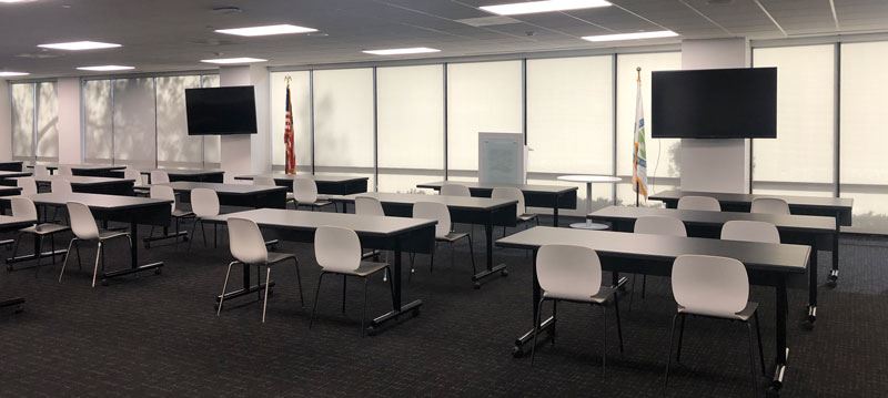 The Community Chest room with tables, chairs, and large displays.